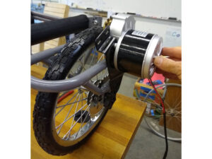 A wheel connected to an aluminum tube frame with a small electric motor mounted to a gear on the wheel.